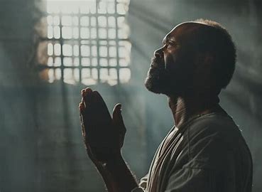 A PRISONER PRAYING IN A PRISON HOUSE