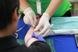 health A healthcare professional administering an injection to a patient's arm during a medical procedure.